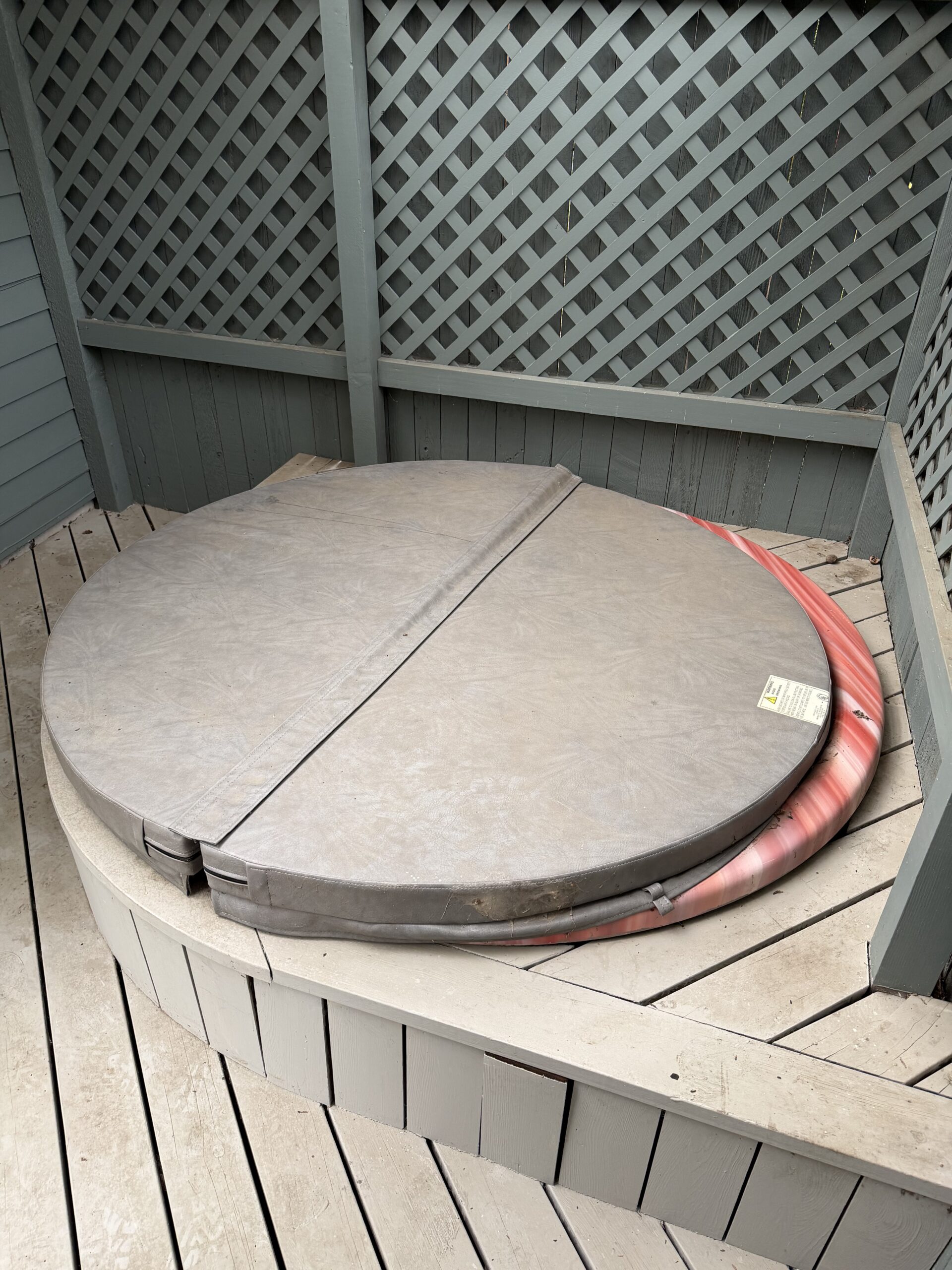 Hot tub built into a covered deck in South Central Salem before removal, with the cover still on